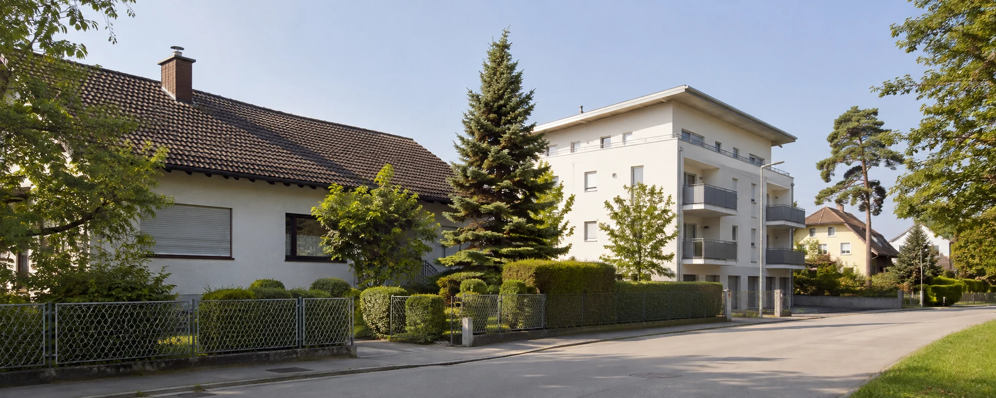 Wohnstraße mit Einfamilienhaus und kleinerem Mehrparteienhaus